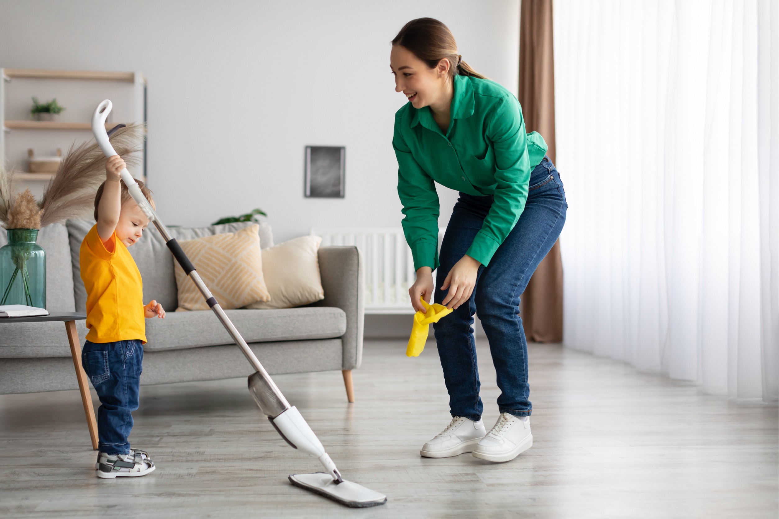 Young mother and toddler son cleaning at home together